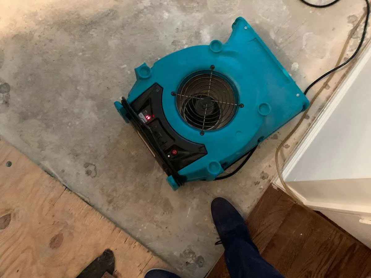 Air mover drying subfloor during Commercial Water Damage Restoration in Fuquay